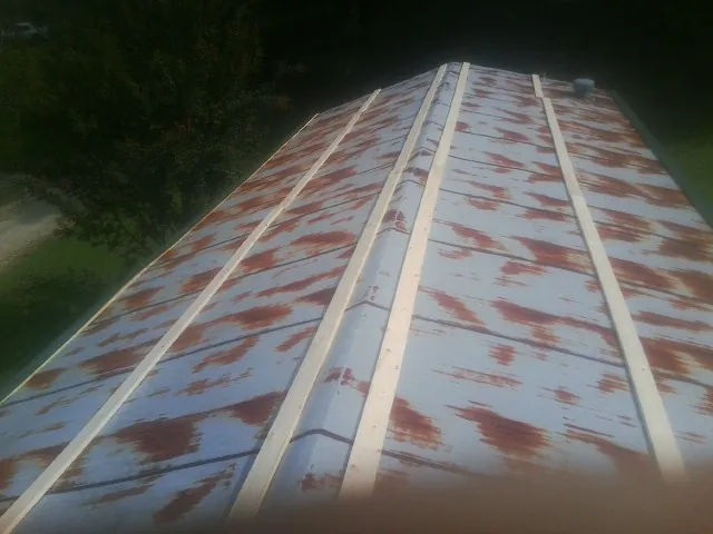 Rusted metal roof panels with new wood purlins before replacement — Storm Damage Roof Repair in Turtle Creek by Roofing Brothers