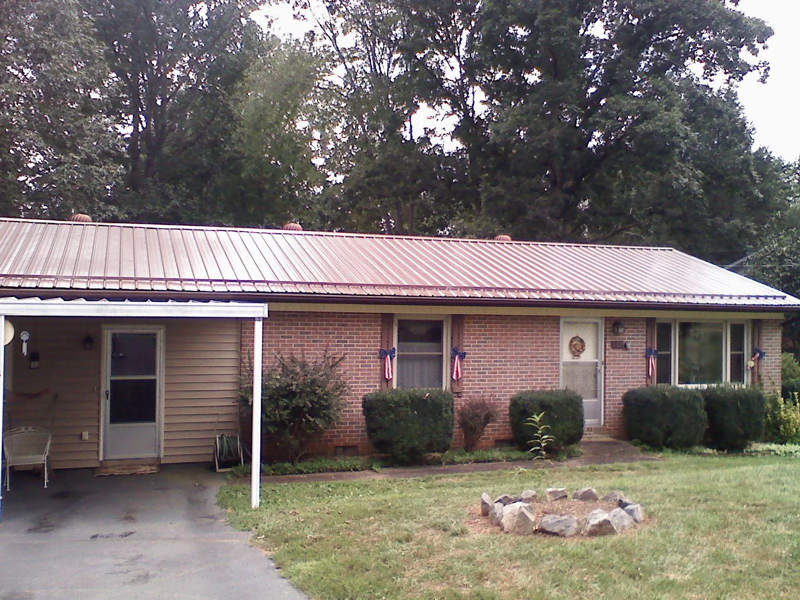 Bronze metal roof and carport on a brick ranch home — Roof Repair work by our crew in Turtle Creek